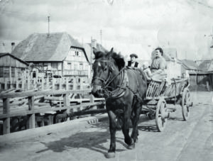 Famille Wotling avec leur fils Bernard,  en voiture à ridelles traversant le pont provisoire de l’Ill (1948).